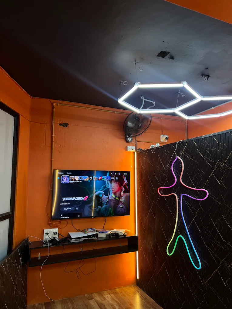 Orange gaming area and wall-mounted screen at Shivam Playworld